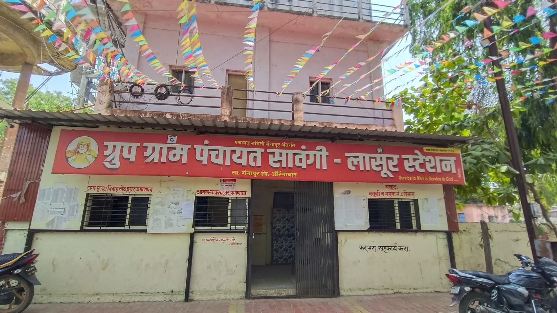 Wide shot of a traditional village council hall in rural Maharashtra with clear blue sky